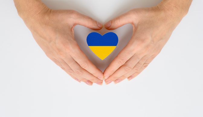 The national flag of Ukraine in female hands. The concept of patriotism, respect and solidarity with the citizens of Ukraine